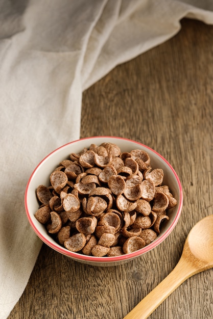 Płatki śniadaniowe o smaku kakao w misce na drewnianym stole