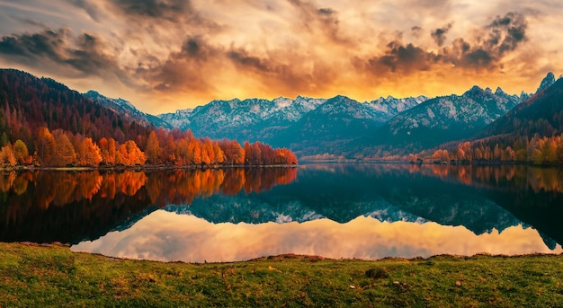 Płatność bajkowy krajobraz z jeziorem jesienią i pięknym zachodem słońca