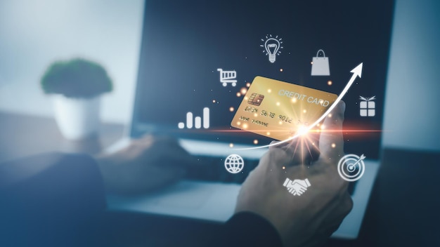 Zdjęcie płatność online za pomocą technologii kart kredytowych biznesmen trzyma złotą kartę kredytową i hologram z zakupami online i płaceniem za pośrednictwem notebooka laptop futurystyczna koncepcja zakupów online e-commerce
