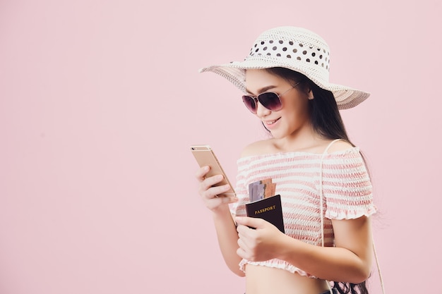 Płatność za zakupy online., Kobieta wesoła korzystających z zakupów online przez smartfon i kartę kredytową w studio różowym tle. Filtry w odcieniach pastelowego różu.