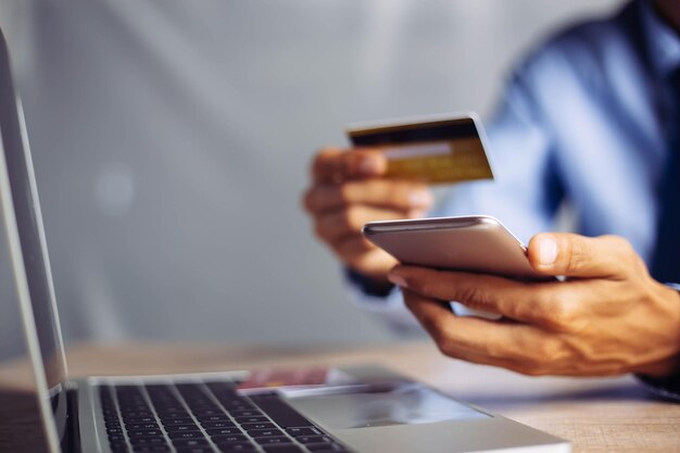 Płatności online ręce trzymające kartę kredytową i używające laptopa Koncepcja zakupów online