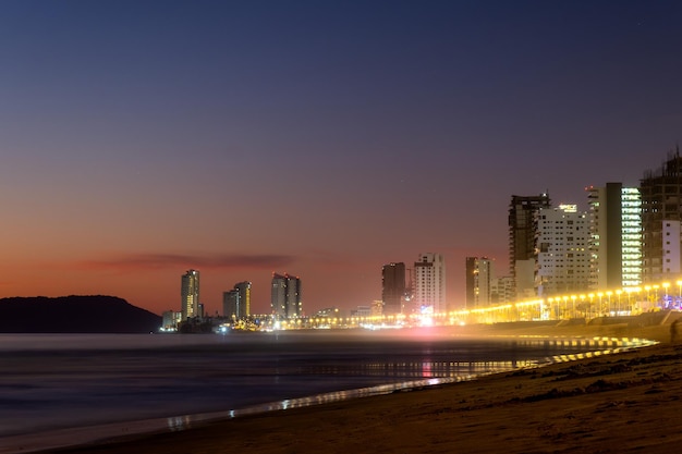 Plaża Mazatlan sinaloa nocą ze świecącym miastem w tle