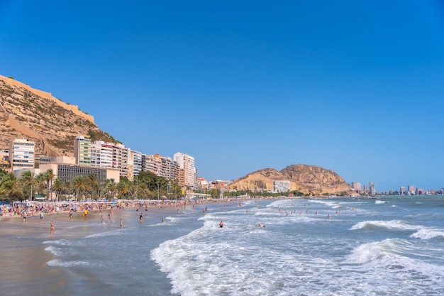 Plaża Postiguet w Alicante z turystami i zamkiem Santa Barbara