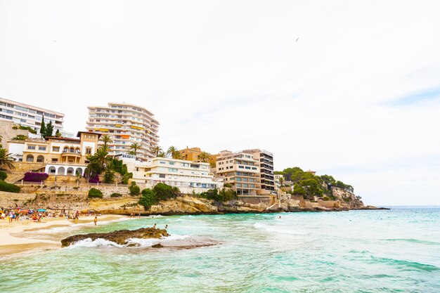 Plaża wśród skał na Palma de Mallorca Ludzie morza hotele i budynki mieszkalne