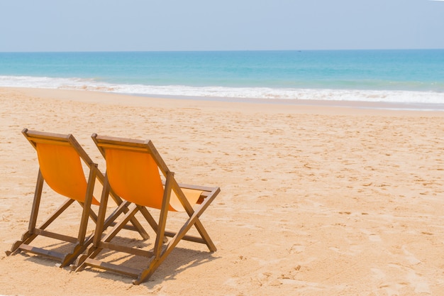 Plażowi krzesła na piaskowatej plaży ocean.