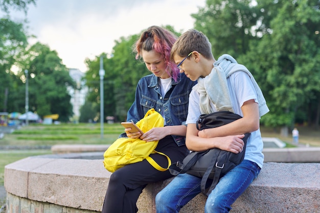 Plenerowy portret dwa opowiada nastolatka z smartphone