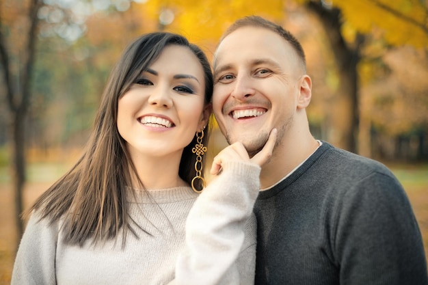 Plenerowy portret międzyetnicznej szczęśliwej pary w jesiennym parku