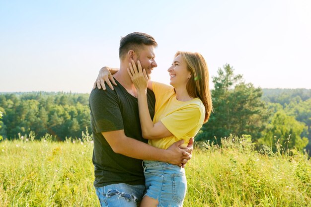 Plenerowy portret szczęśliwej pary w średnim wieku zakochanych w objęciach