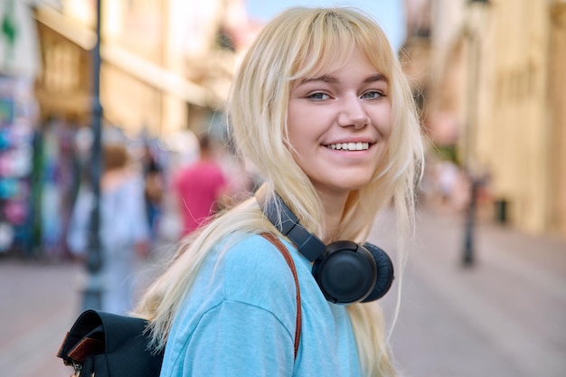 Plenerowy portret szczęśliwej uśmiechniętej nastolatki w wieku 17 lat