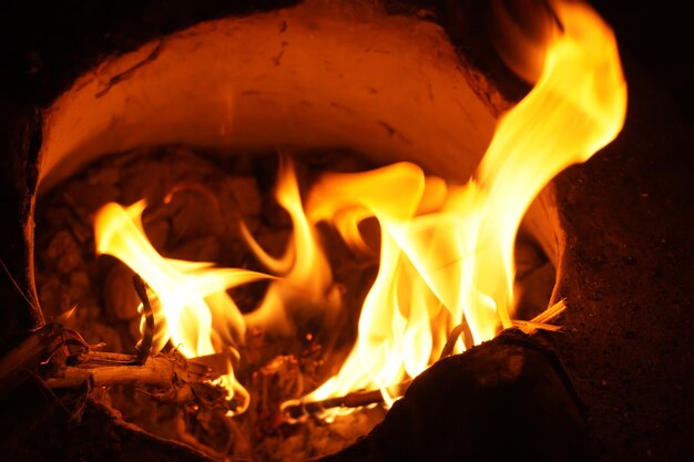 Zdjęcie płomienie ognia i iskry światła na czarnym tle z energią cieplną w punkcie paliwowym w nocy