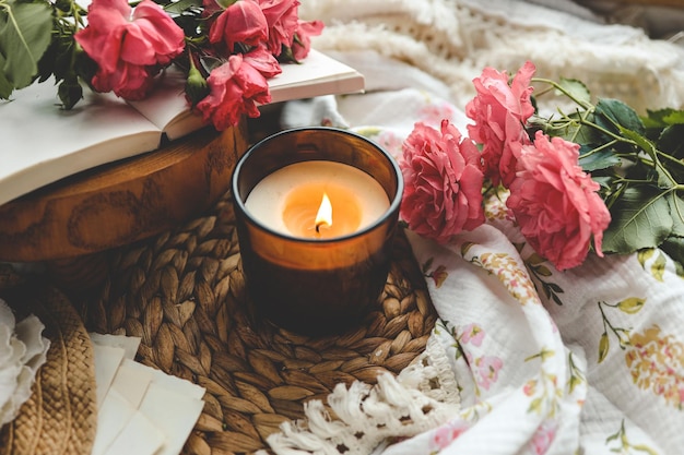 Płonąca świeca książka i róże estetyczne letnie zdjęcie