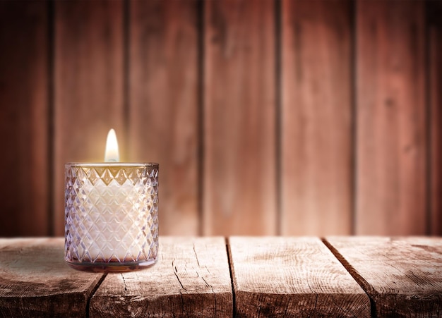 Zdjęcie płonąca świeca na starym drewnianym stole drewniane tło
