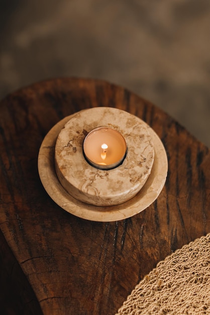 Płonąca świeca w marmurowym stojaku na drewnianym stole Szczegóły we wnętrzu