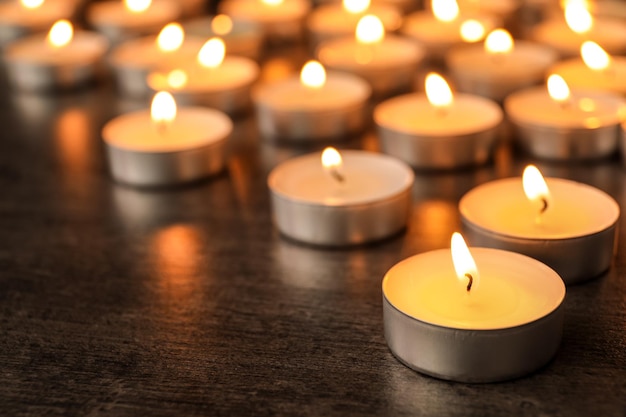 Płonące świece na drewnianym stole dla tekstu Symbol smutku