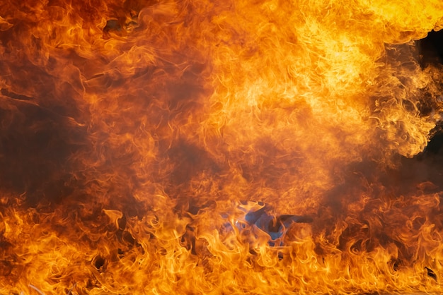 Zdjęcie płonący płomień ognia z olejem opałowym, benzyna spalanie ponad pojemnik, pożar dymu i zanieczyszczenia