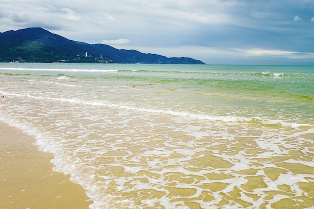 Plusk wody na China Beach w Danang w Wietnamie. Nazywana jest również plażą Non Nuoc. Morze Południowochińskie i Góry Marmurowe w tle.