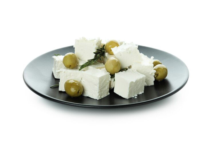 Zdjęcie płyta z serem feta, oliwkami i rozmarynem na białym tle na białej powierzchni
