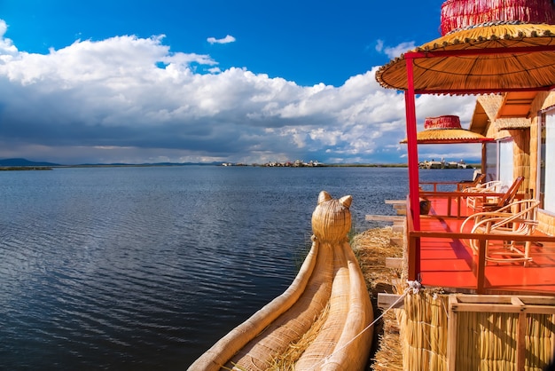 Pływająca wyspa Uros i tradycyjna łódź Totora na jeziorze Titicaca w pobliżu miasta Puno, Peru