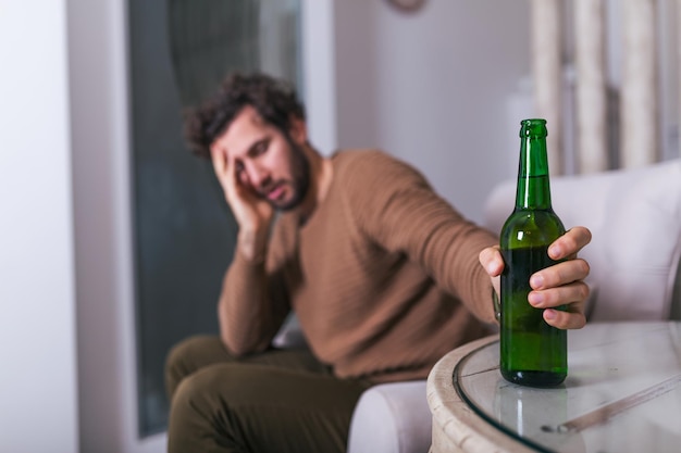 Po Pracy Przygnębiony Facet Siedzi Na Kanapie I Pije Zimne Piwo. Ręka Trzyma Szklankę, Sam Człowiek Pije Do Domu. Alkoholizm, Uzależnienie Od Alkoholu I Koncepcja Ludzi