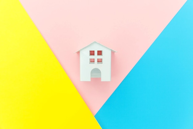 Po prostu zaprojektuj z miniaturowym białym domkiem z zabawkami na niebieskim, żółtym, różowym pastelowym, kolorowym modnym geo...