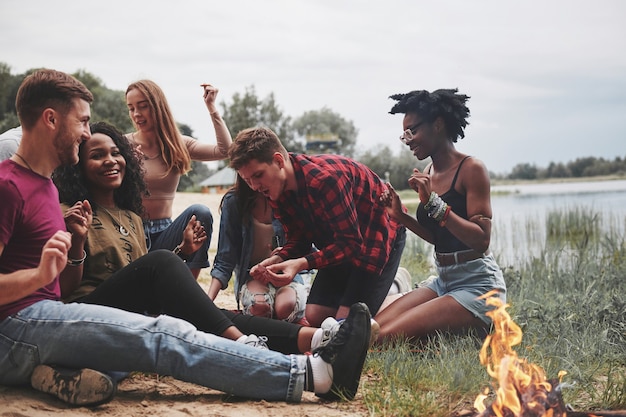 Pochmurna pogoda. Grupa ludzi ma piknik na plaży. Przyjaciele bawią się w weekendy.