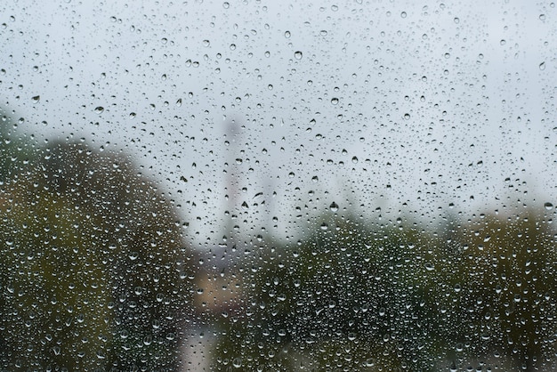 Pochmurny deszczowy dzień. Krople deszczu na powierzchni okna, tekstura tło, miejsce. Koncepcja złej pogody
