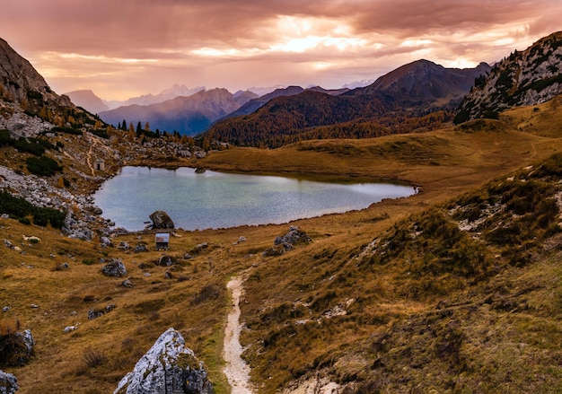 Pochmurny poranek jesień alpejskie Dolomity górska scena Spokojna ścieżka Valparola i widok na jezioro Belluno Włochy