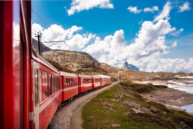 Pociąg idący wzdłuż jeziora w Szwajcarii z niektórymi lodowymi krajobrazami szwajcarskich Alp