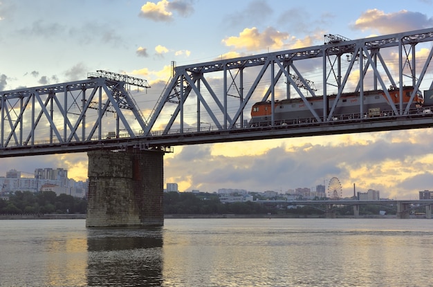 Pociąg na moście nad Ob Most kolejowy nad rzeką Wielką Syberyjską wysokimi budynkami