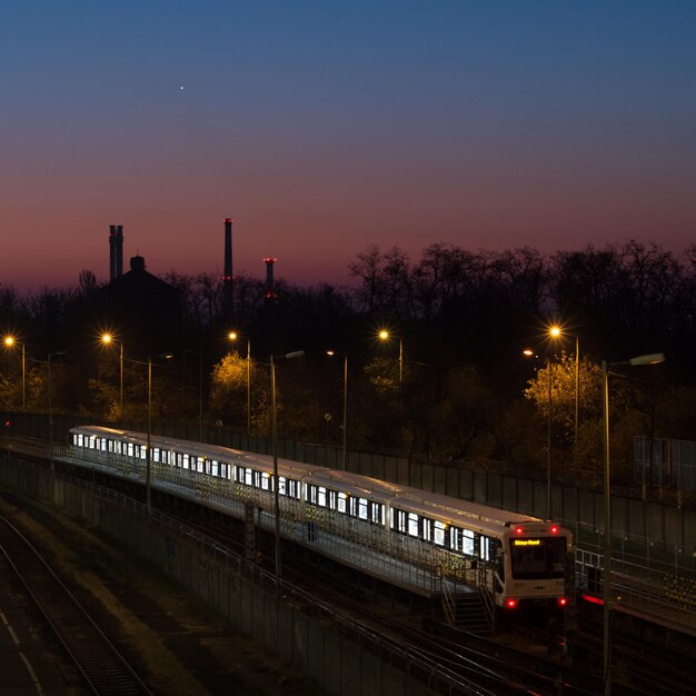 Zdjęcie pociąg na oświetlonym mieście na tle nocnego nieba