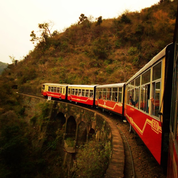 Zdjęcie pociąg pasażerski na moście w pobliżu góry