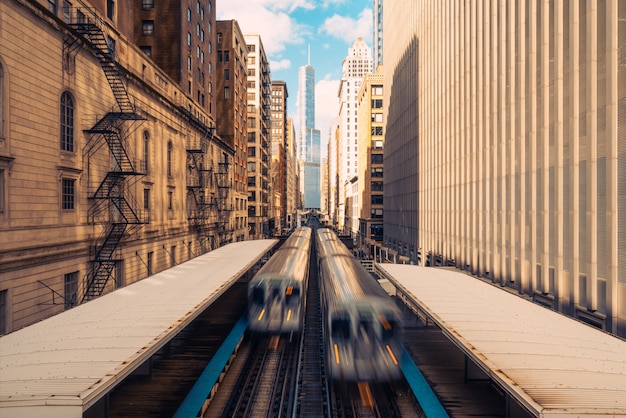 Zdjęcie pociągi przybywających do stacji kolejowej między budynkami w centrum chicago, illinois.