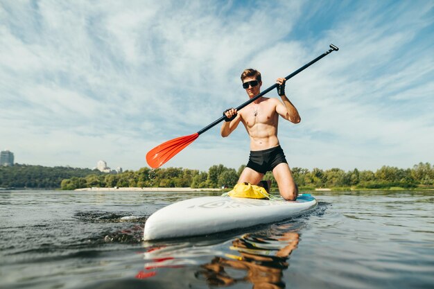 Pociągi sportowe na desce do wiosłowania na morzu na tle pięknego krajobrazu morskiego