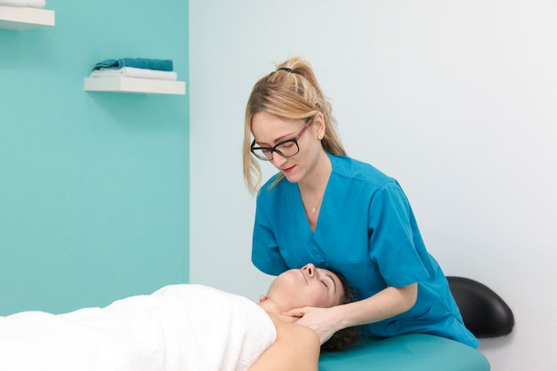Zdjęcie początkujący lekarz stosujący masaż medyczny u klienta