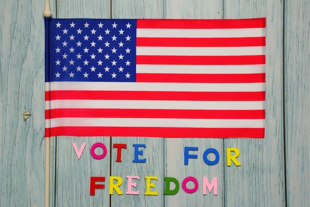 Pod Flagą Usa Napis Vote For Freedom Jest Wyłożony Wielokolorowymi Literami Na Drewnianym Tle