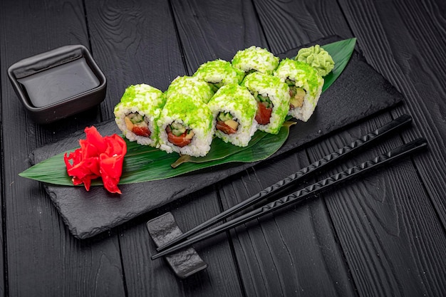 Podano kalifornijską rolkę sushi z krabowym ogórkiem awokado i kawiorem tobiko