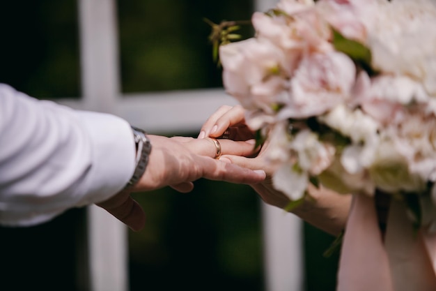 Podczas ceremonii ślubnej nowożeńcy wymieniają się obrączkami, w pobliżu łuku ślubnego. obrączki ślubne