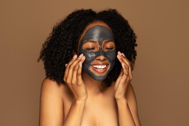 Podekscytowana czarna dama ciesząca się nową maską organiczną