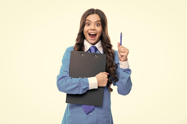 Podekscytowana twarz Nastolatek dziewczyna w koszuli i krawacie na sobie mundur biurowy, trzymając schowek na białym tle