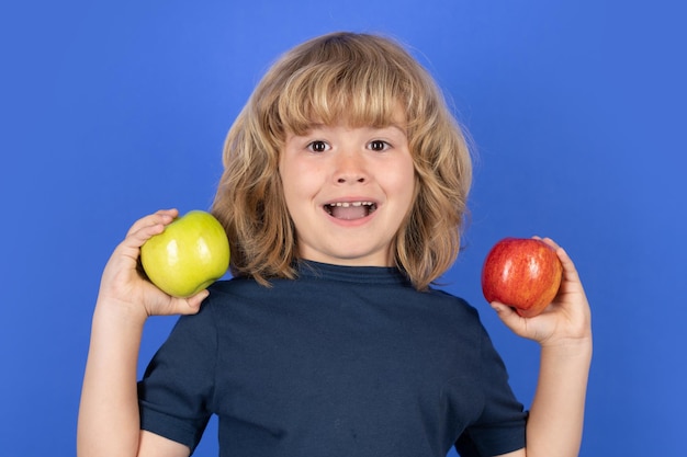 Podekscytowany dziecko trzyma jabłko na odosobnionym tle