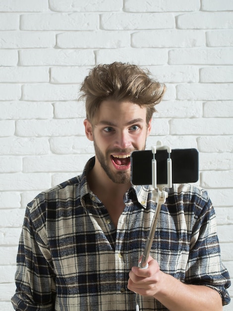 Podekscytowany mężczyzna używa kijka do selfie