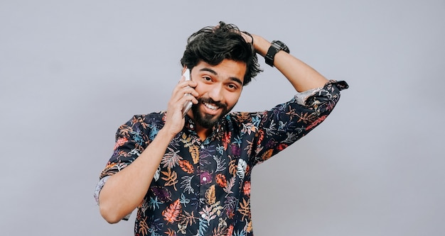 podekscytowany młody indyjski student na telefonie, używając telefonu na telefon
