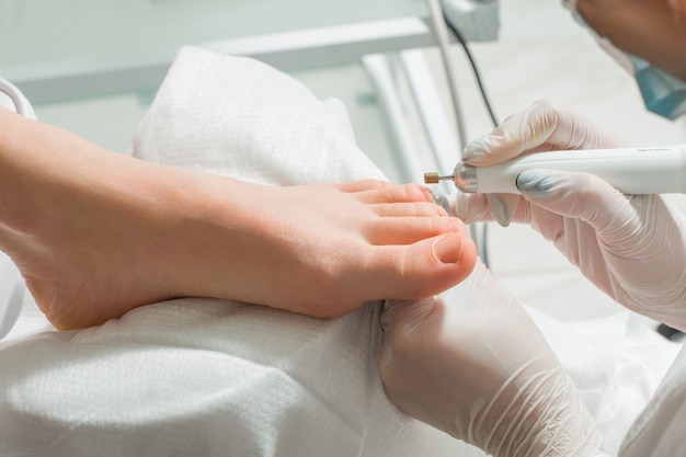 Podiatra, który zajmuje się kosmetycznymi zabiegami na paznokciach kobiet