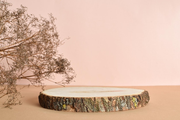 Podium z naturalnego drewna z suszonymi kwiatami na beżowym tle Minimalistyczna scena brandingowa