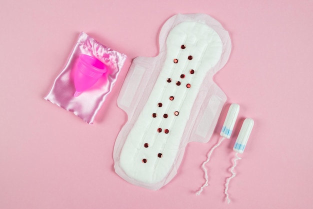 Podkładka tampon i kubeczek menstruacyjny na różowym tle Pojęcie menstruacji w krytyczne dni Higiena kobieca w krytyczne dni