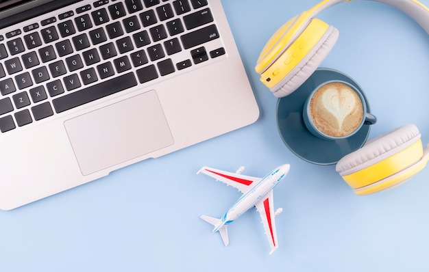 Podróż flatlay Laptop słuchawki samolot i kawa planowanie letnich wakacji koncepcja Letni obszar roboczy