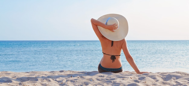 Podróż Nad Morze. Dziewczyna W Kostiumie Kąpielowym I Kapeluszu Do Opalania Na Plaży.