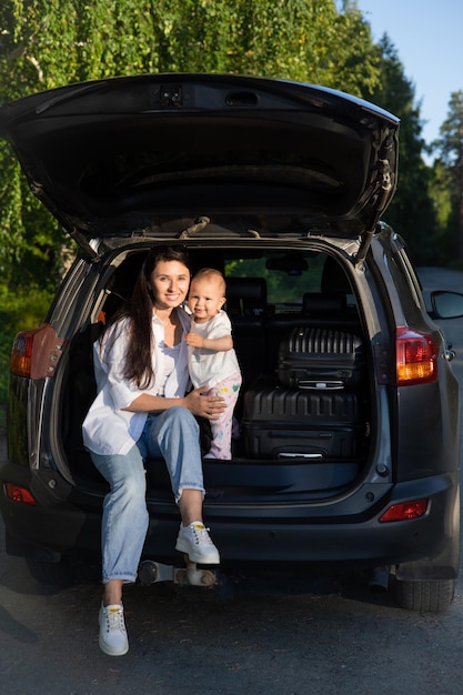 Podróż samochodem Podróż z dzieckiem samochodem Matka i córka siedzą w samochodzie z otwartym bagażnikiem