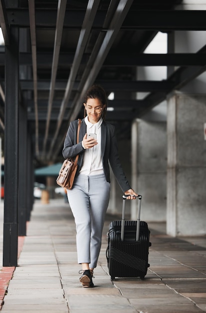 Podróż telefoniczna i walizka z kobietą biznesu spacerującą po parkingu lotniska na świeżym powietrzu w mieście Mobilny bagaż i dojazdy z młodą pracownicą podczas międzynarodowej podróży do pracy
