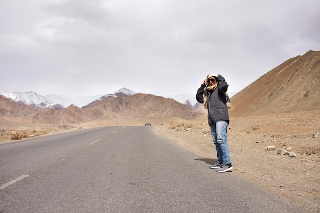 Podróżnicy tajlandzka kobieta podróżują i pozują do zrobienia zdjęcia z krajobrazem wysokiej góry na autostradzie Srinagar Leh Ladakh w wiosce Leh Ladakh w Dżammu i Kaszmirze w Indiach w sezonie zimowym